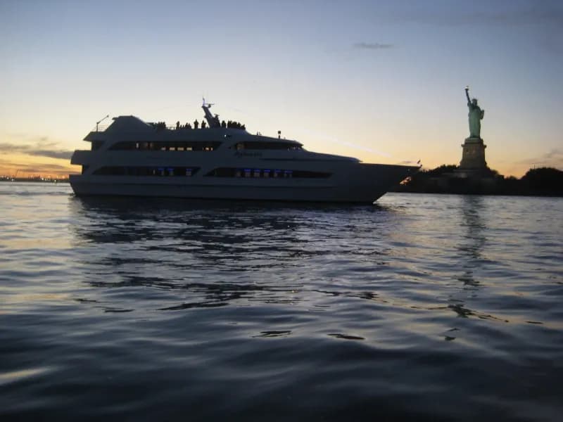 The Atlantis yacht cruising past the Statue of Liberty
